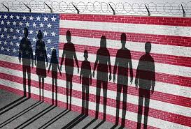 Silhouettes of people holding hands in front of an American flag on a fence.