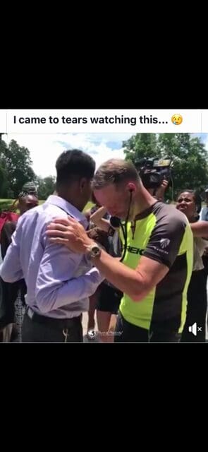 Two men in an emotional embrace outdoors.