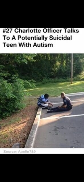 Two boys sitting on the curb with a fallen skateboard.