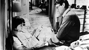 Two men sitting on the floor reading books in a casual setting.