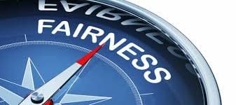Close-up of a compass pointing to "Fairness".